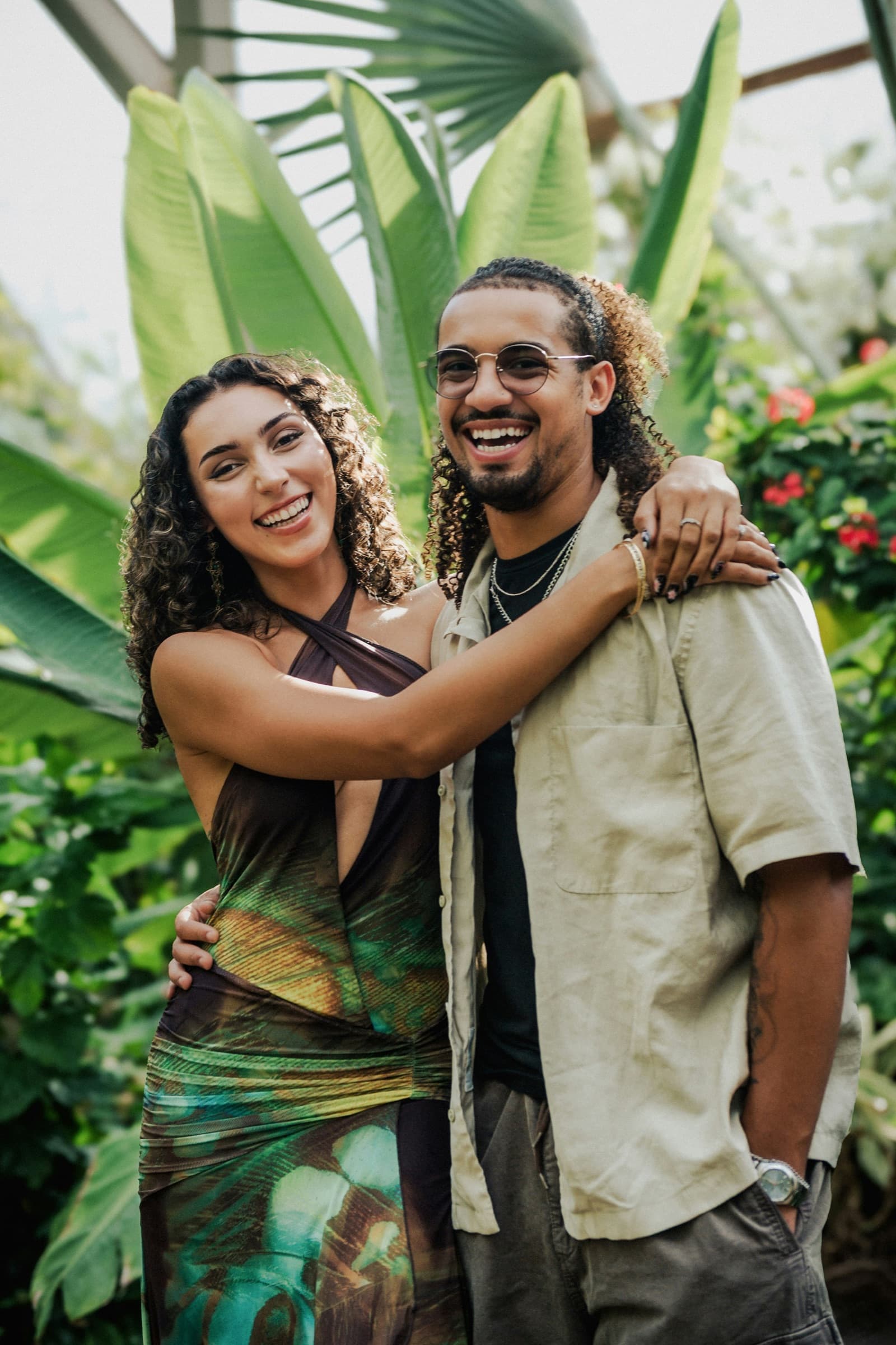 A couple standing close together, both laughing