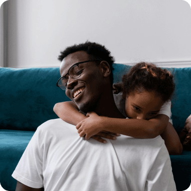 A father laughing with his daughter on his shoulders